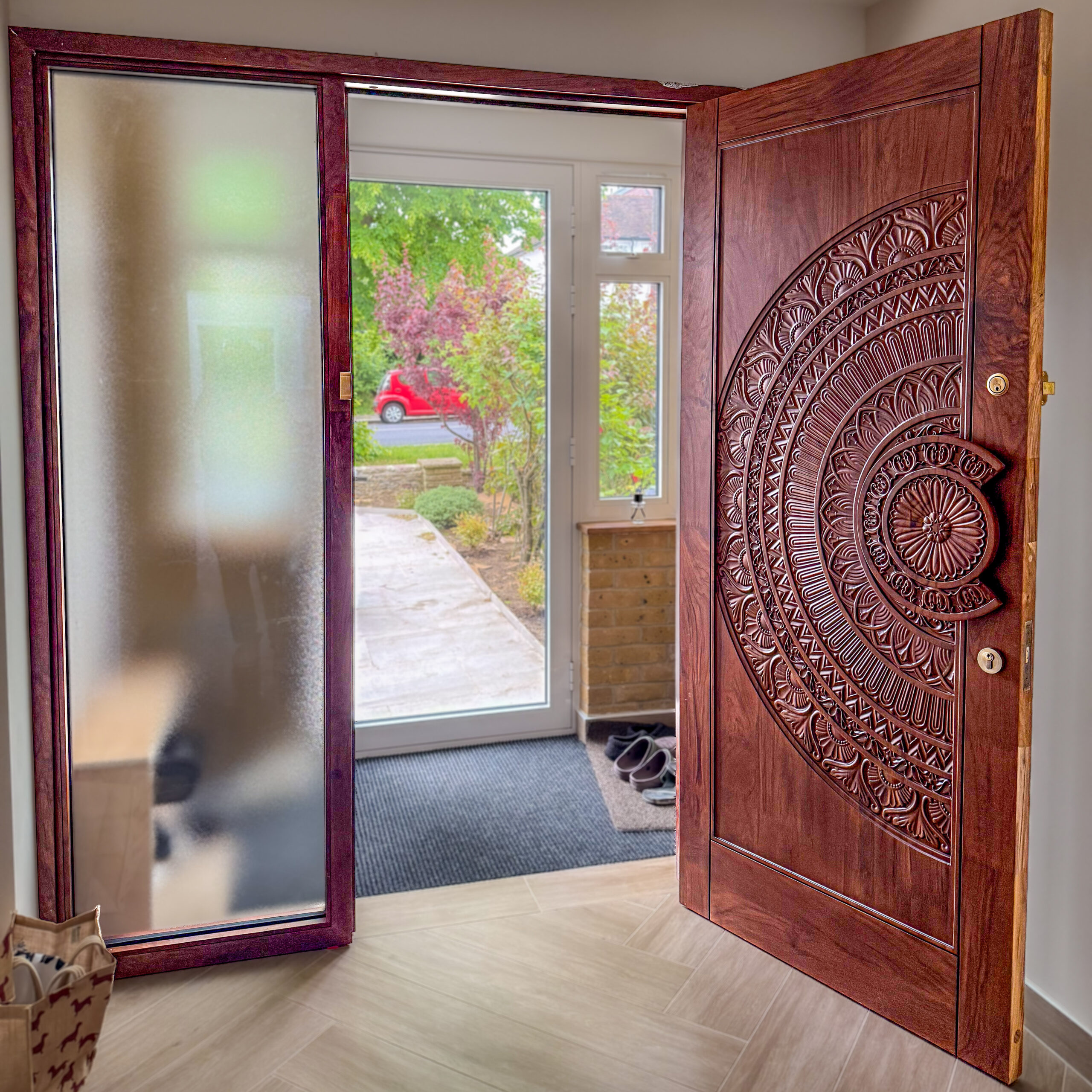 Hand-carved solid teak front door with a custom carved handle, installed in a private home in London